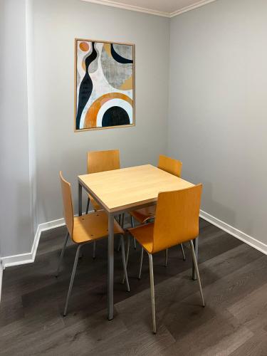 a table and chairs in a room with a painting at Caloundra Central Apartment Hotel Official in Caloundra