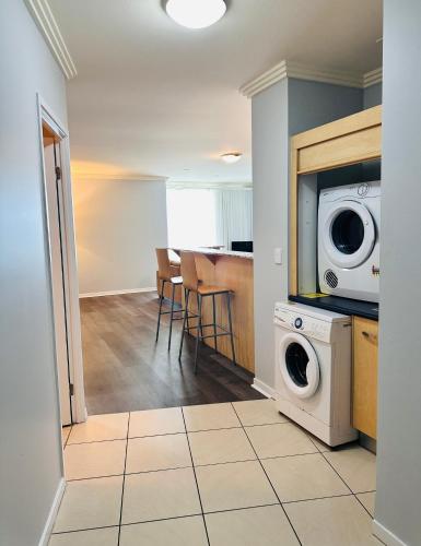 a kitchen with a washer and dryer in a room at Caloundra Central Apartment Hotel Official in Caloundra