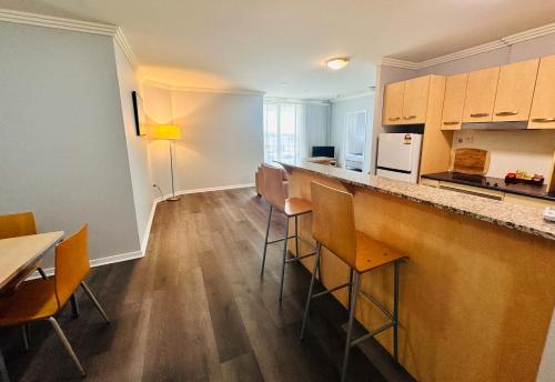 a kitchen with a bar with chairs and a counter top at Caloundra Central Apartment Hotel Official in Caloundra