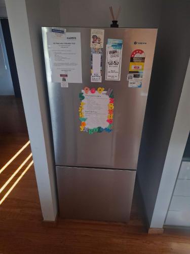 a stainless steel refrigerator with magnets and papers on it at Bashams Beach House 7 Sun Crt Middleton - No Linen Included in Middleton