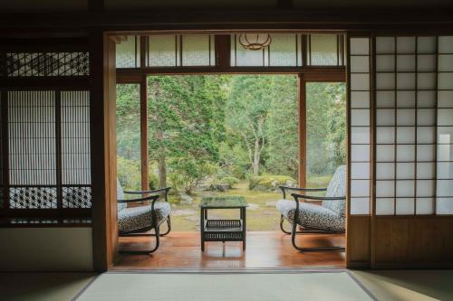 an open door to a patio with chairs and a table at Ochiairo in Izu