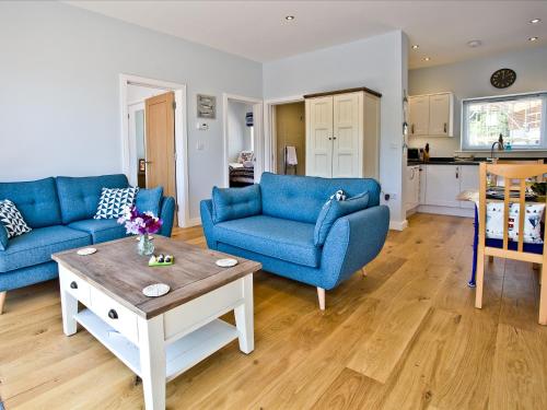 a living room with blue couches and a coffee table at Dunlin 4 - The Cove in Brixham