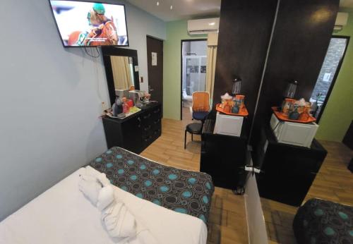 a hotel room with a bed and a tv on the wall at Villa Alejandra Merida Yucatan in Mérida