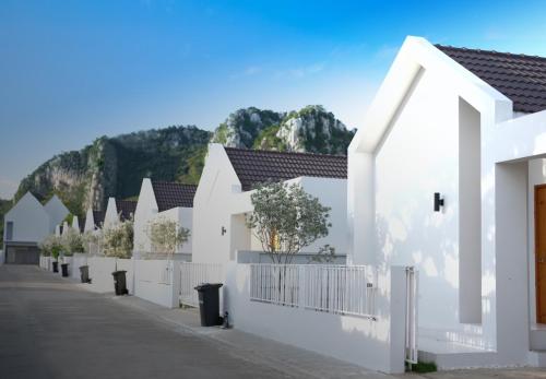 szereg białych domów z płotem w obiekcie Za-Ngob 39 Luxury 3BR Pool Villa with Mountain View w mieście Ban Phra Phutthabat Mai