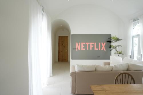 salon z białą kanapą i tabliczką netflix w obiekcie Za-Ngob 39 Luxury 3BR Pool Villa with Mountain View w mieście Ban Phra Phutthabat Mai