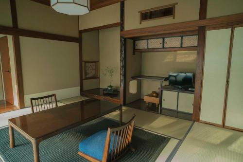 a living room with a table and a tv at Ochiairo in Izu