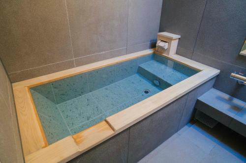 a bathroom with a tub with a glass shower at Ochiairo in Izu
