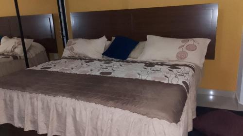 un grande letto con testiera marrone e cuscini bianchi di Tesoro Palmas Resort a Mazatlán