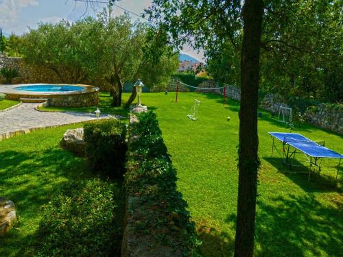 a park with a picnic table and a pool at Villa in Čilipi near Dubrovnik with Pool in Čilipi
