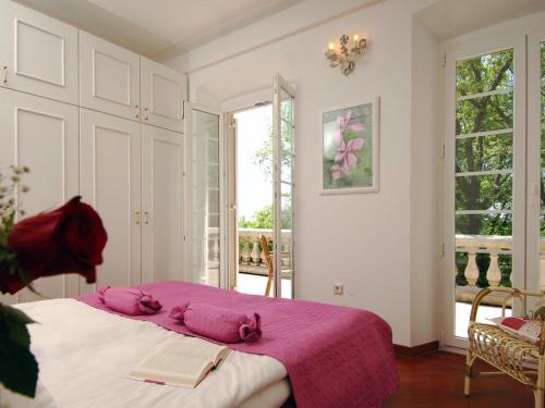 a bedroom with a bed with pink sheets and a book at Villa in Čilipi near Dubrovnik with Pool in Čilipi