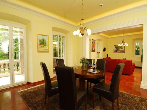 a dining room with a table and a red couch at Villa in Čilipi near Dubrovnik with Pool in Čilipi