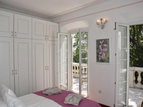 a bedroom with white cabinets and a bed with a purple blanket at Villa in Čilipi near Dubrovnik with Pool in Čilipi