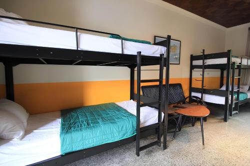 two bunk beds in a room with a table and a chair at Yellow House in Hengchun