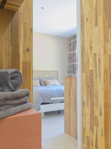 a bedroom with a bed and a room with a mirror at Villa Jasmin Regusse in Régusse