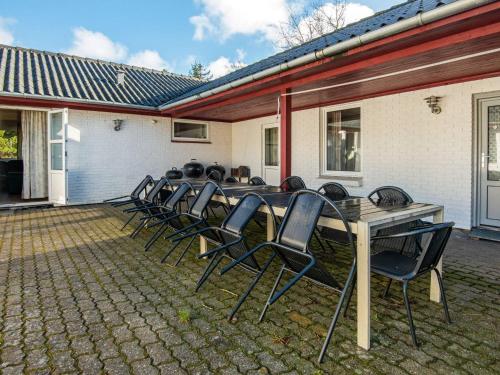 a group of chairs sitting around a wooden table at 18 person holiday home in Rømø in Kongsmark