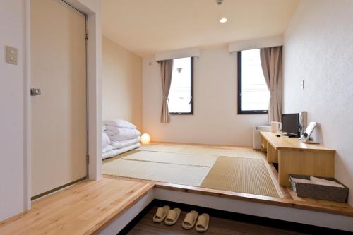 a living room with a desk and a bed at Pangoo Onna Japanese Style Hotel in Onna