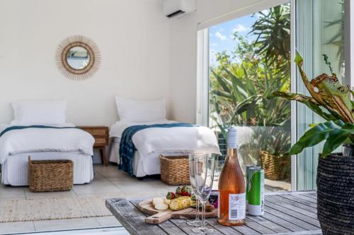a room with a table with a bottle of wine at 'Pandandus Rise' 1-9 Avocet Parade in Peregian Beach