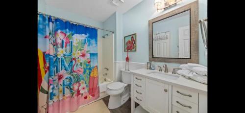 a bathroom with a sink and a toilet and a mirror at Crescent Palm North Myrtle Beach in Myrtle Beach
