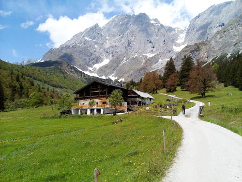 a person walking down a dirt road next to a mountain at Landhaus Rieding in Mühlbach am Hochkönig