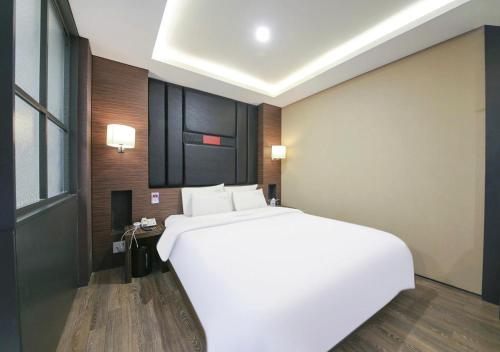 a large white bed in a hotel room at Arieti A in Gimhae