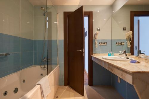 ein Bad mit einer Badewanne, einem Waschbecken und einer Dusche in der Unterkunft Hotel La Serrana, antiguo 40 Nudos in Avilés