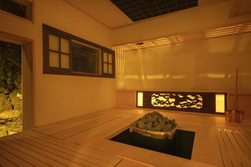 a room with a fireplace in the middle of a room at Ochiairo in Izu