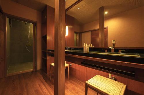 a bathroom with a shower and a sink and a mirror at Ochiairo in Izu