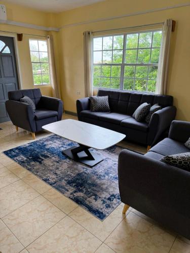 a living room with couches and a coffee table at Bliss Oasis Hideaway in Buccoo