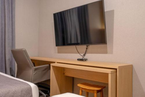 a room with a desk with a television and a chair at Cheonho Aria Hotel in Seoul