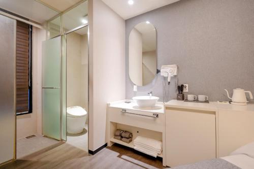 a bathroom with a sink and a mirror at Cheonho Aria Hotel in Seoul