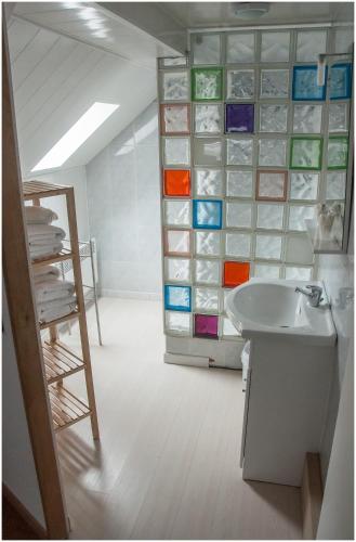 La salle de bains est pourvue d'un lavabo et d'une paroi en verre. dans l'établissement Hôtel Gambetta, à Reims