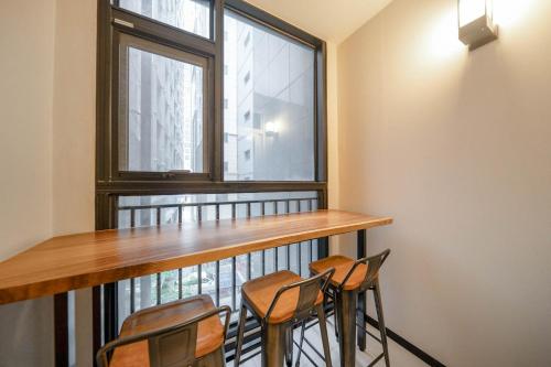 a balcony with chairs and a table and a window at Cheonho Aria Hotel in Seoul