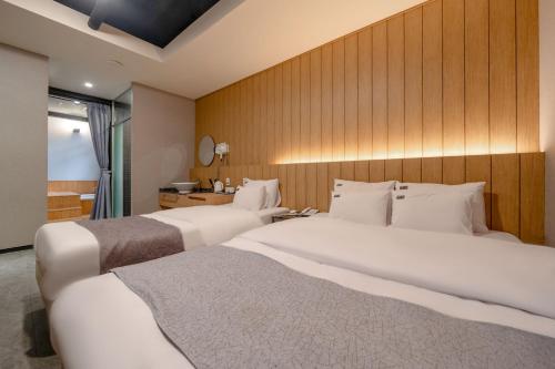 two beds in a hotel room with at Cheonho Aria Hotel in Seoul