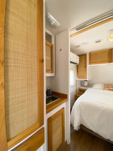 a small bedroom with a bed and a sink at Boutique Campers La Ventana, a pasos de la playa in La Ventana