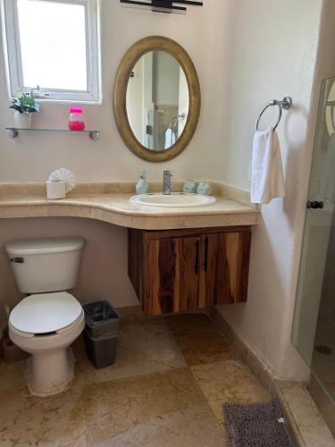a bathroom with a toilet and a sink with a mirror at blue angel 22 a unos paso de la 5v y la playa in Playa del Carmen