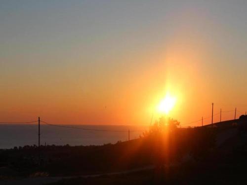 a sunset with the sun setting on the horizon at Pleasant tent with swimming pool in Fermo