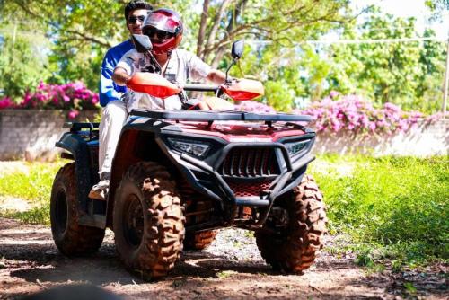 a man riding a four wheeler on a dirt road at Nandi Daybreak - Holiday Homes in Bengaluru