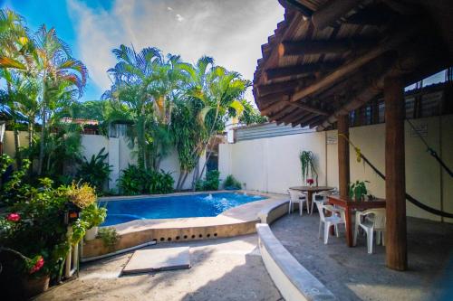 a swimming pool in a backyard with a table and chairs at Hotel Casa Boquita Estudios equipados con alberca y jacuzzi in Zihuatanejo