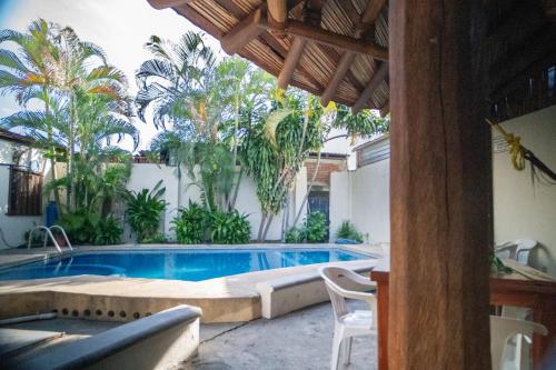 a swimming pool in a backyard with palm trees at Hotel Casa Boquita Estudios equipados con alberca y jacuzzi in Zihuatanejo