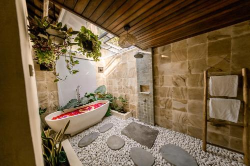 a bathroom with a bath tub with plants in it at Sunsura Villas in Nusa Penida