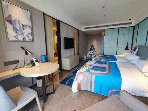 a bedroom with a large bed with a desk and a table at Echarm Hotel Nanning the MixC Dongmeng Business District in Nanning