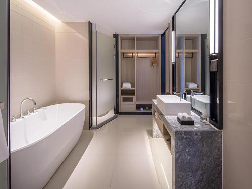 a bathroom with a tub and two sinks and a bath tub at Echarm Hotel Nanning the MixC Dongmeng Business District in Nanning