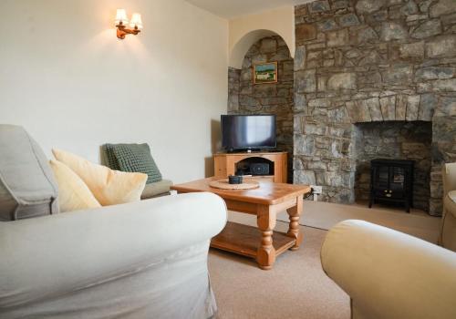 un salon avec un canapé et une cheminée dans l'établissement 3 Prospect Place, New Quay, sleeps 6, parking, sea views, dog friendly, à New Quay