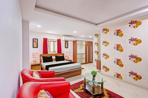 a bedroom with a bed and a red chair at Super Townhouse Seethammadhara Junction Formerly Vijaya Residency in Raspari Palao