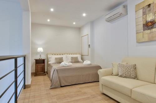a bedroom with a bed and a couch at Palazzo Violetta in Sliema