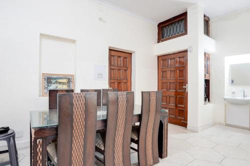 a dining room with a table and chairs and a sink at Super Hotel O Sector 21 Faridabad in Faridabad