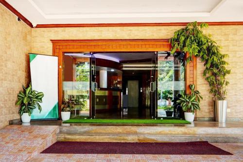 an entrance to a building with potted plants at Super Collection O Viyyur Thrissur in Trichūr