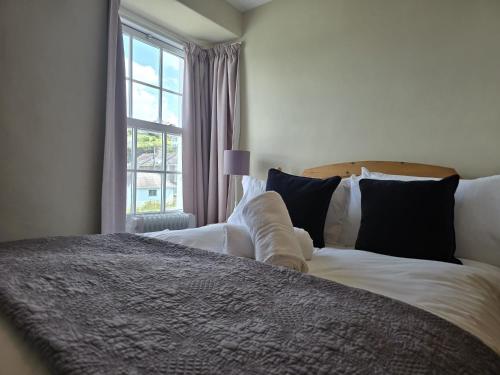 une chambre avec un grand lit avec une fenêtre dans l'établissement 3 Prospect Place, New Quay, sleeps 6, parking, sea views, dog friendly, à New Quay