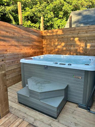 a hot tub on a deck with a wooden fence at Adventure Haven Hot Tub & Quidi Vidi Charm in St. John's