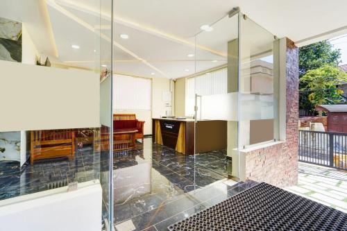 a glass shower door in a room with a table at Townhouse Trivandrum Padmanabhaswamy Temple Formerly Rezt N Relaz Inn in Trivandrum